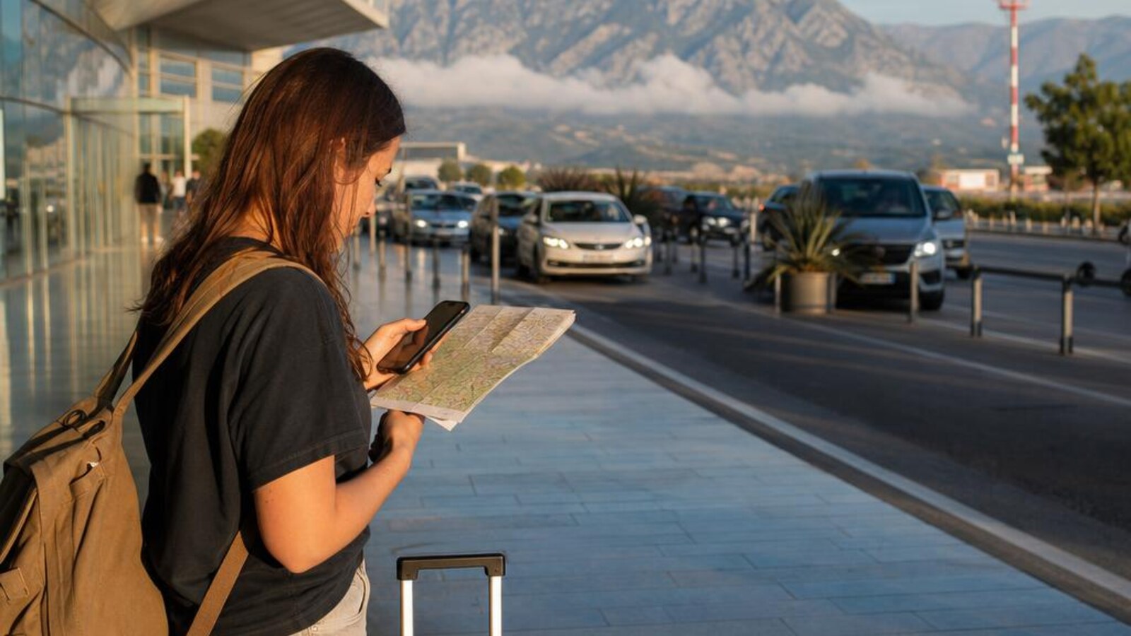 AI-generated editorial photograph of a traveler preparing a phone and luggage near a modern Albanian airport arrival area